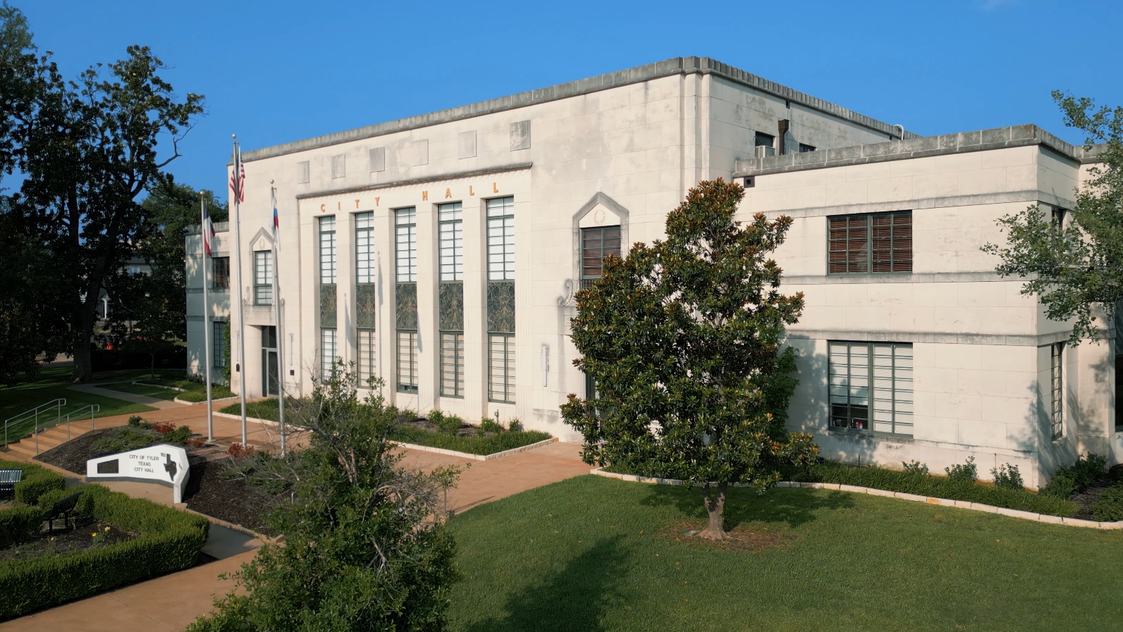 Exterior view of Tyler, Texas City Hall, showcasing its classic architectural design under a clear blue sky.